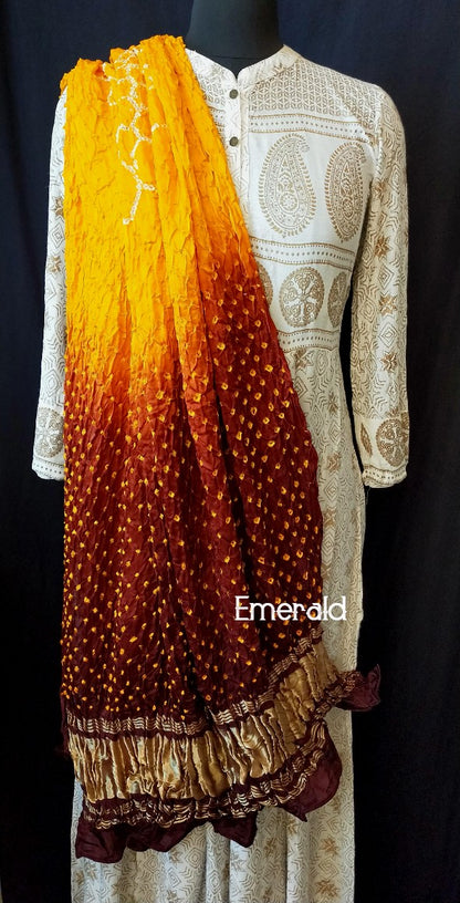 An ancient craft of 5000 years old,the term `Bandhani` is derived from the word `Bandhan' that means tying up, mainly used in the states of Gujarat and Rajasthan.This one is a shaded yellow and maroon Bandhani on pure gajji silk with gold tissue patta at both ends. A total must-have for your festive/ wedding wardrobe.