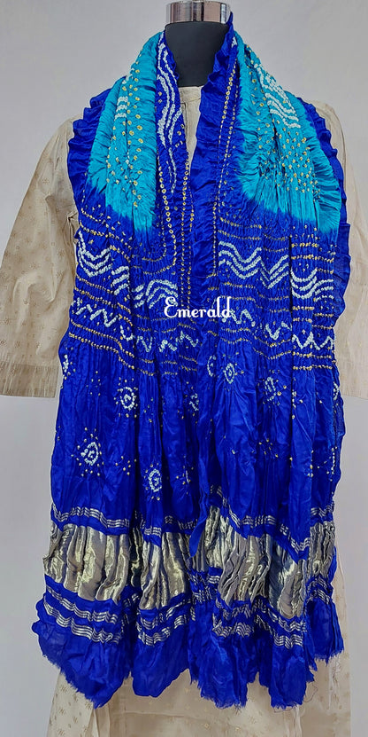 An ancient craft of 5000 years old, the term `Bandhani` is derived from the word `Bandhan' that means tying up, mainly used in the states of Gujarat and Rajasthan. This one is a light and dark blue Bandhani on pure gajji silk with gold tissue patta at both ends. A total must-have for your festive/ wedding wardrobe.