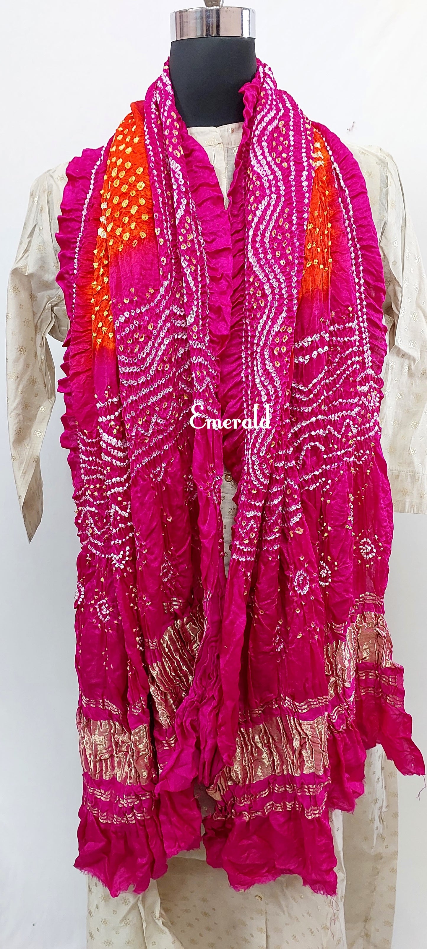 An ancient craft of 5000 years old, the term `Bandhani` is derived from the word `Bandhan' that means tying up, mainly used in the states of Gujarat and Rajasthan. This one is a shaded pink and orange Bandhani on pure gajji silk with gold tissue patta at both ends. A total must-have for your festive/ wedding wardrobe.