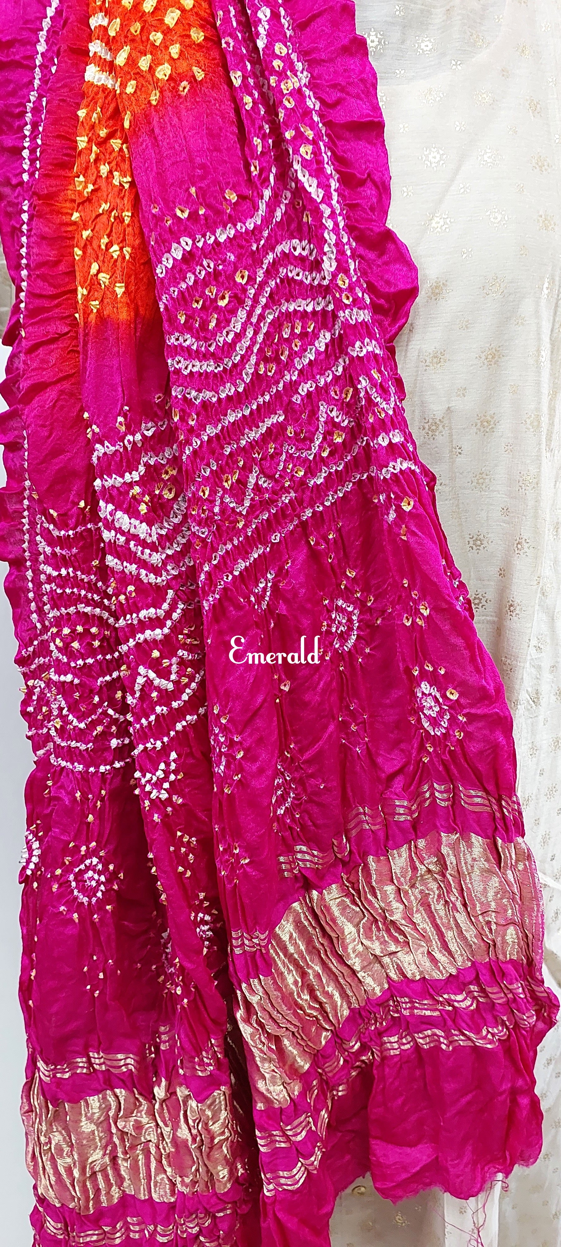 An ancient craft of 5000 years old, the term `Bandhani` is derived from the word `Bandhan' that means tying up, mainly used in the states of Gujarat and Rajasthan. This one is a shaded pink and orange Bandhani on pure gajji silk with gold tissue patta at both ends. A total must-have for your festive/ wedding wardrobe.