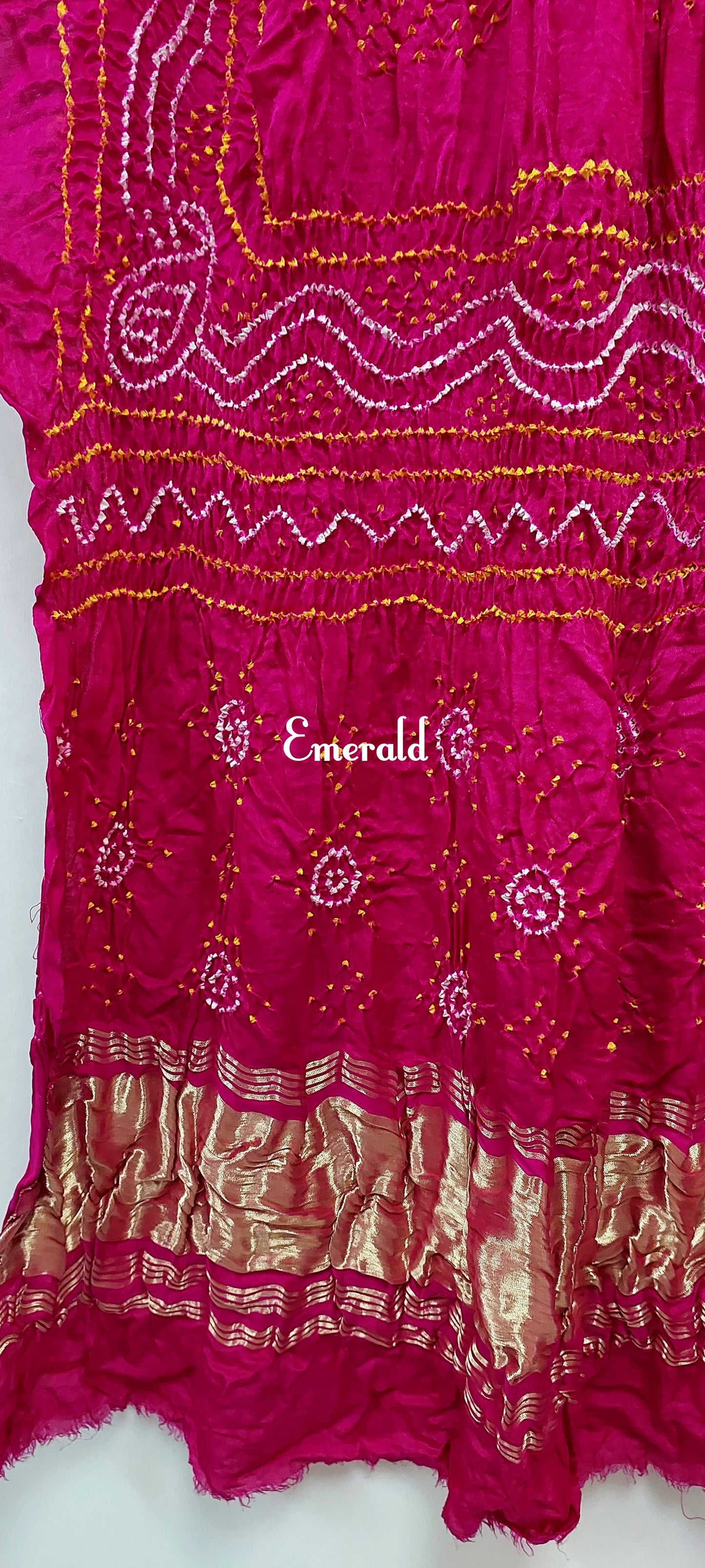 An ancient craft of 5000 years old, the term `Bandhani` is derived from the word `Bandhan' that means tying up, mainly used in the states of Gujarat and Rajasthan. This one is a pink Bandhani on pure gajji silk with gold tissue patta at both ends. A total must-have for your festive/ wedding wardrobe. 