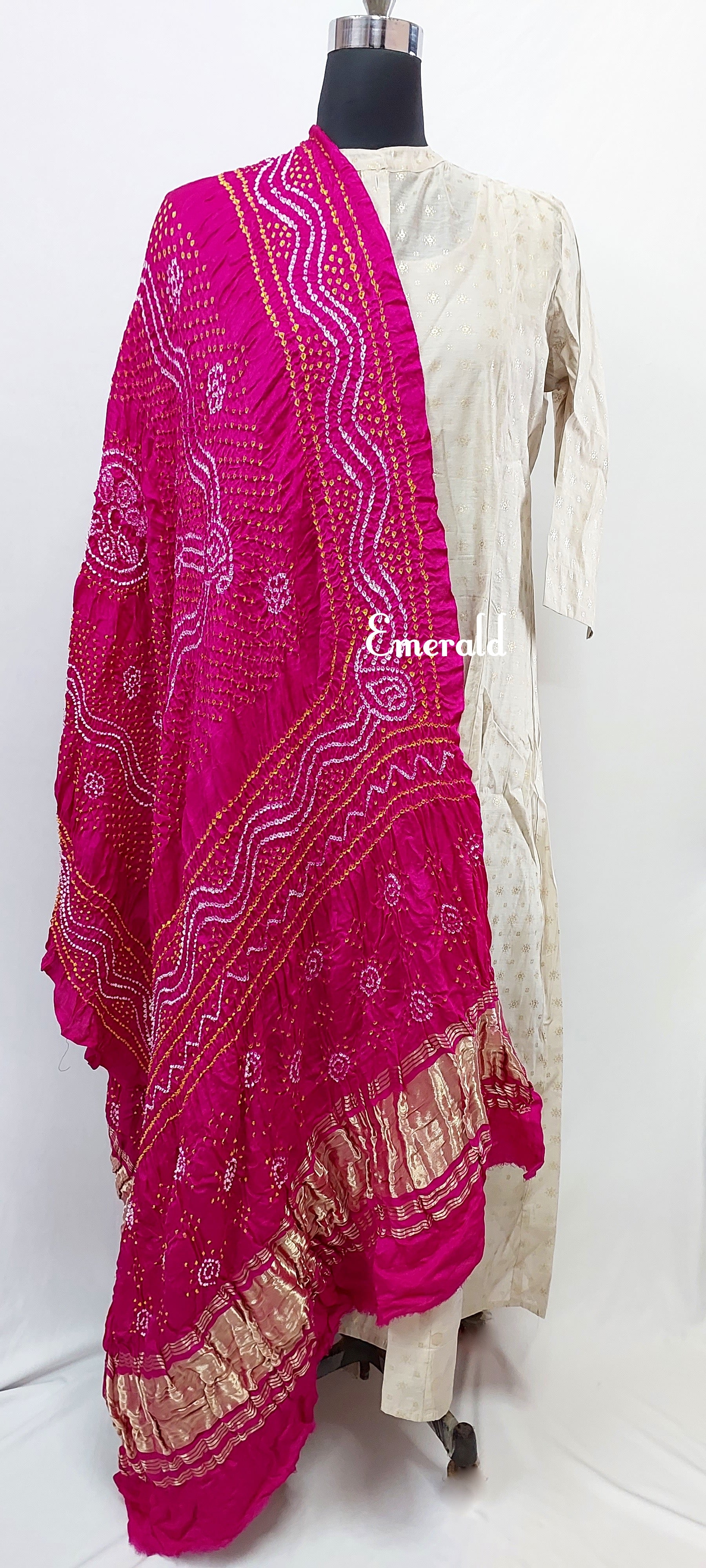 An ancient craft of 5000 years old, the term `Bandhani` is derived from the word `Bandhan' that means tying up, mainly used in the states of Gujarat and Rajasthan. This one is a pink Bandhani on pure gajji silk with gold tissue patta at both ends. A total must-have for your festive/ wedding wardrobe. 