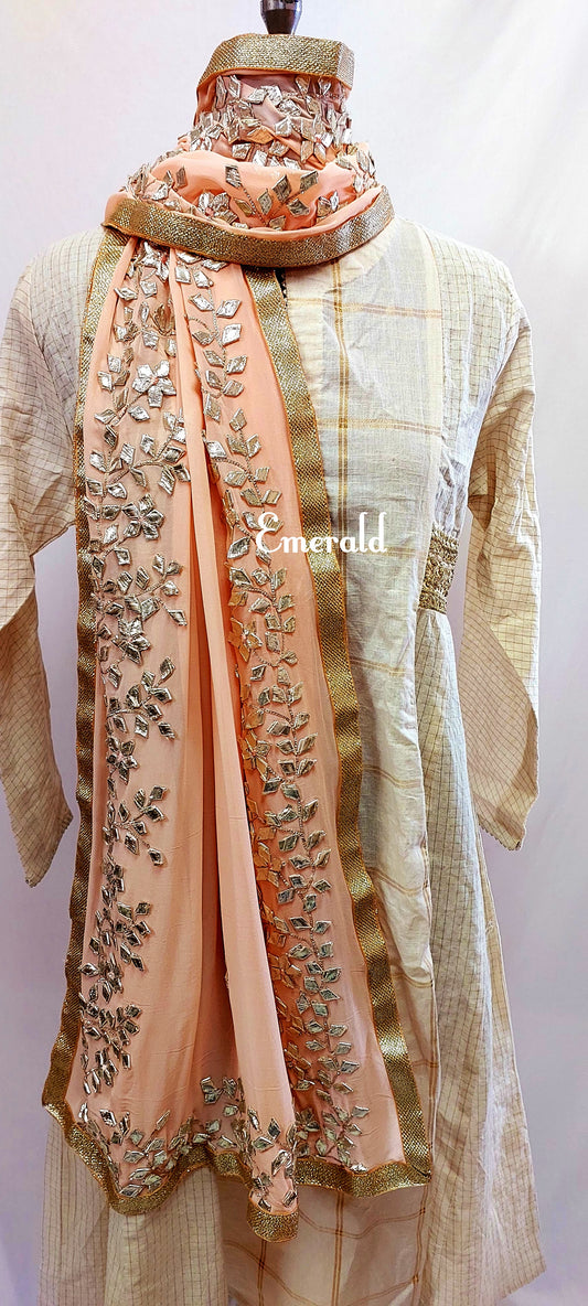 An elegant,embroidered peach Dupatta in georgette. Dupatta is bordered with a broad patch of silver gota patti work and butis in the middle area.Trimmed with an antique gold border. Perfect for any events in the wedding season!Dupatta measurements:Length-2.4mWidth-39inWash Care- Dry Clean Only.