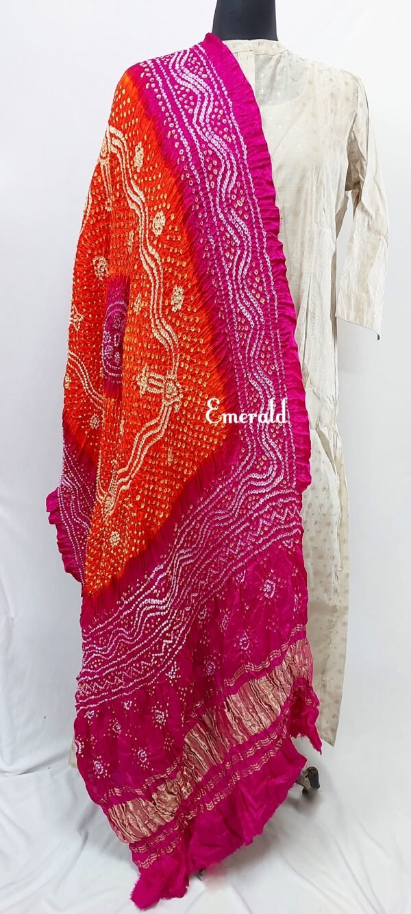 An ancient craft of 5000 years old, the term `Bandhani` is derived from the word `Bandhan' that means tying up, mainly used in the states of Gujarat and Rajasthan. This one is a shaded pink and orange Bandhani on pure gajji silk with gold tissue patta at both ends. A total must-have for your festive/ wedding wardrobe.