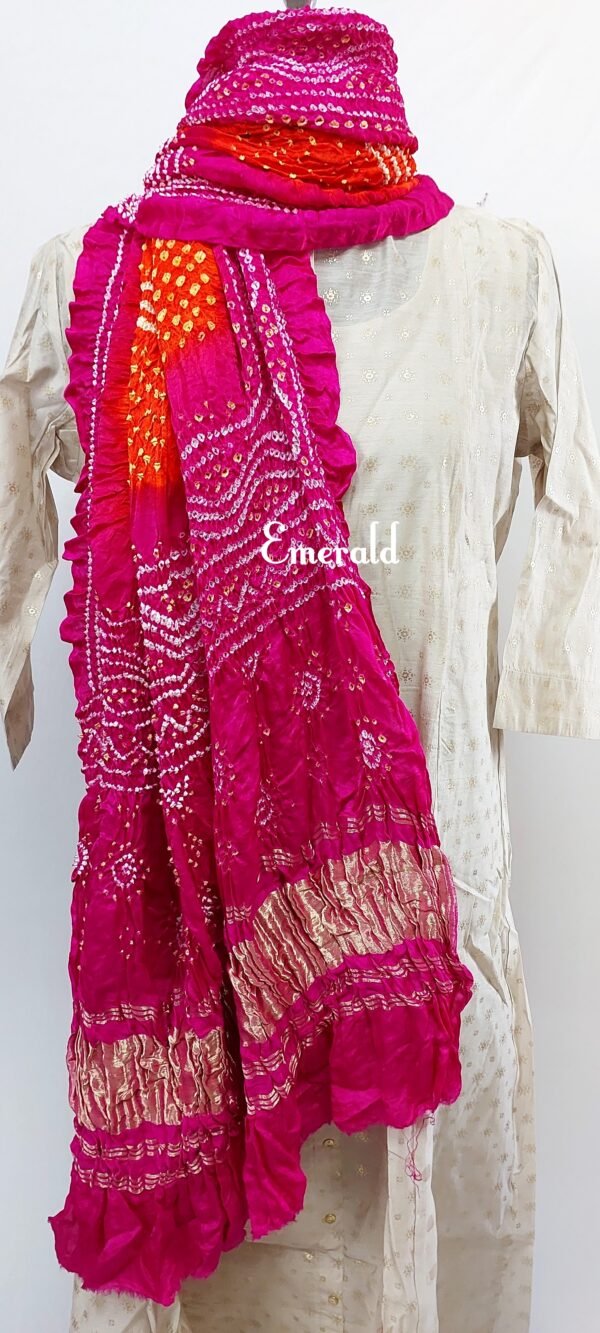 An ancient craft of 5000 years old, the term `Bandhani` is derived from the word `Bandhan' that means tying up, mainly used in the states of Gujarat and Rajasthan. This one is a shaded pink and orange Bandhani on pure gajji silk with gold tissue patta at both ends. A total must-have for your festive/ wedding wardrobe.