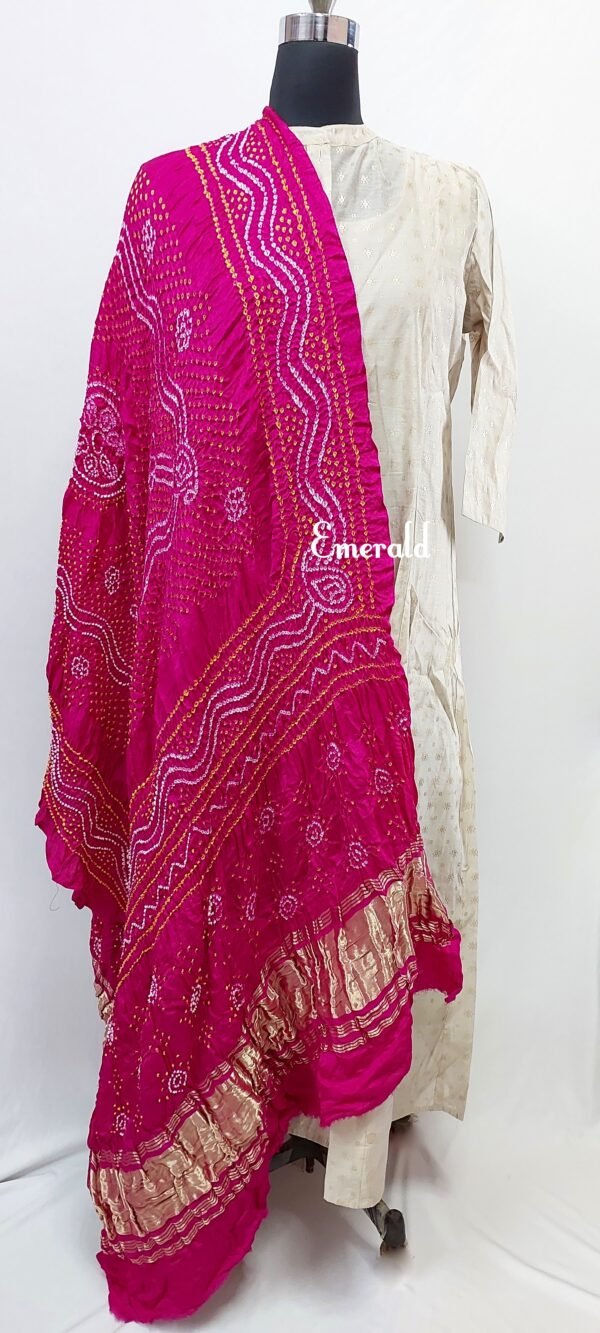 An ancient craft of 5000 years old, the term `Bandhani` is derived from the word `Bandhan' that means tying up, mainly used in the states of Gujarat and Rajasthan. This one is a pink Bandhani on pure gajji silk with gold tissue patta at both ends. A total must-have for your festive/ wedding wardrobe.